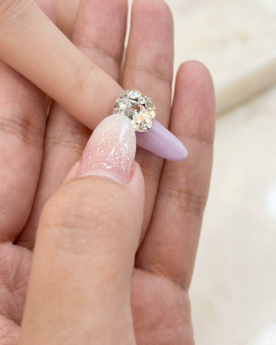 Pincel pequeño de nail art aplicando cuidadosamente una fina capa de gel base transparente sobre la uña.