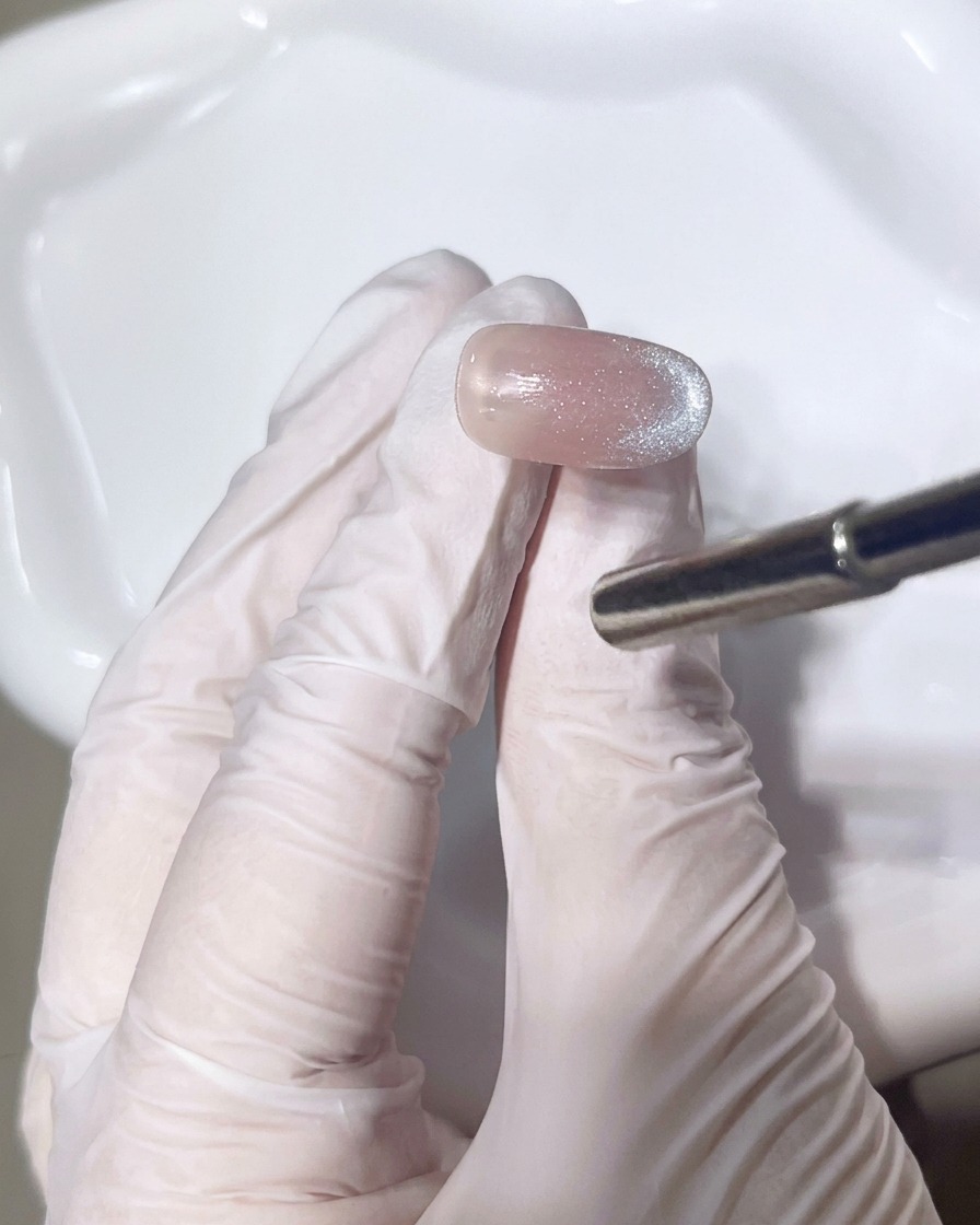 Primer plano de un pincel aplicando una segunda capa de gel brillante para perfeccionar el degradado.
