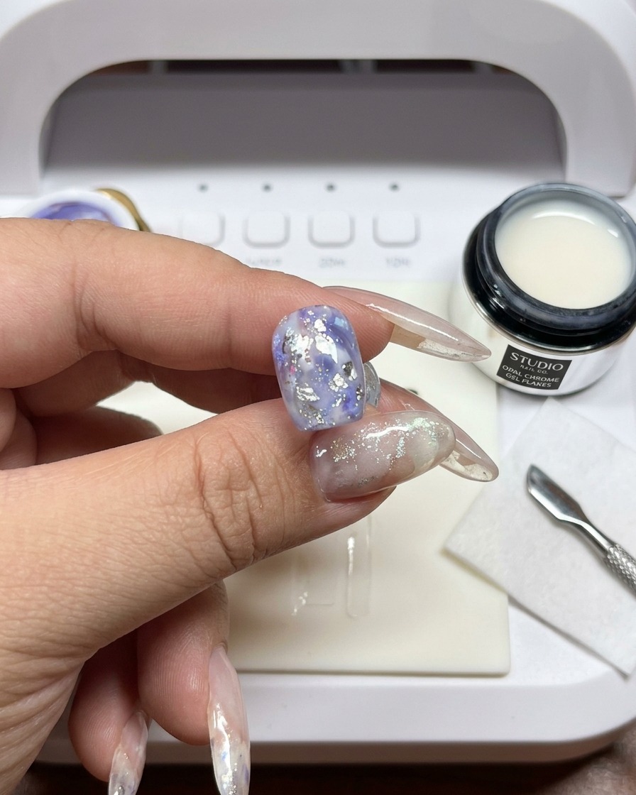 Un pincel difuminando los bordes del gel blanco sobre la uña.