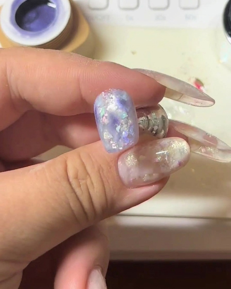 Primer plano de una uña con gel cat-eye siendo imantada para intensificar el destello.