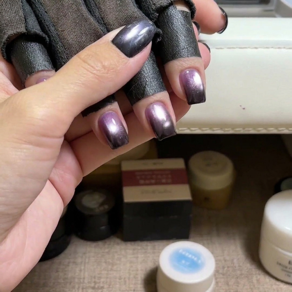 Un pincel aplicando esmalte gel cat eye azul sobre una uña natural.