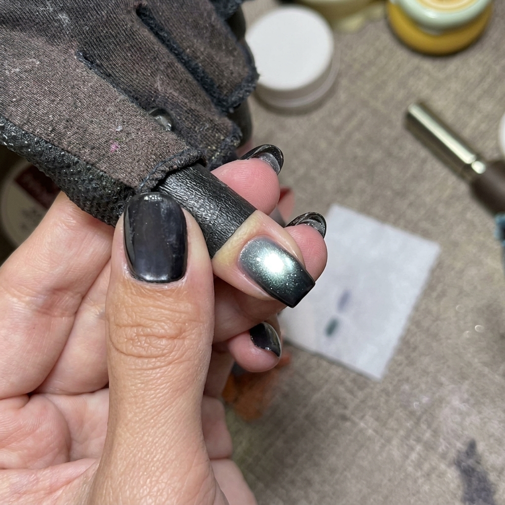 Uñas cat eye azules curándose bajo una lámpara UV.