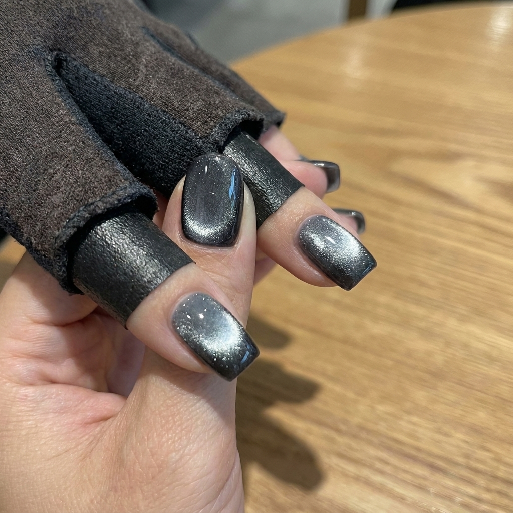 Una mano con esmalte gel cat eye azul descansando dentro de una lámpara UV para el proceso final de curado.
