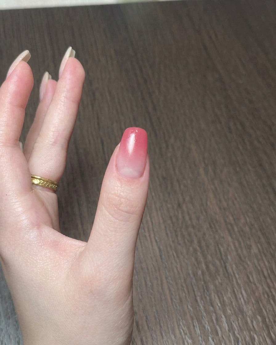 Una lámpara portátil en miniatura curando el esmalte de gel en una uña.