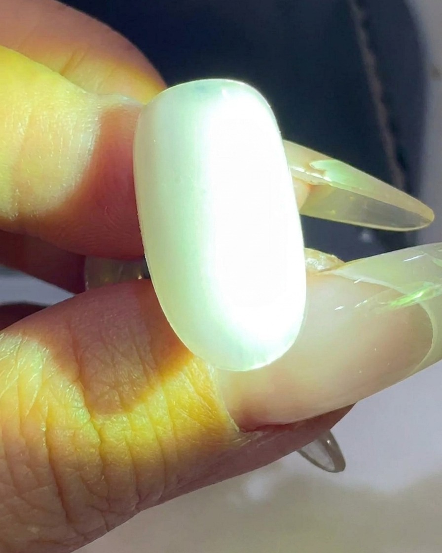 Un tip de uña siendo curado bajo una lámpara UV/LED.