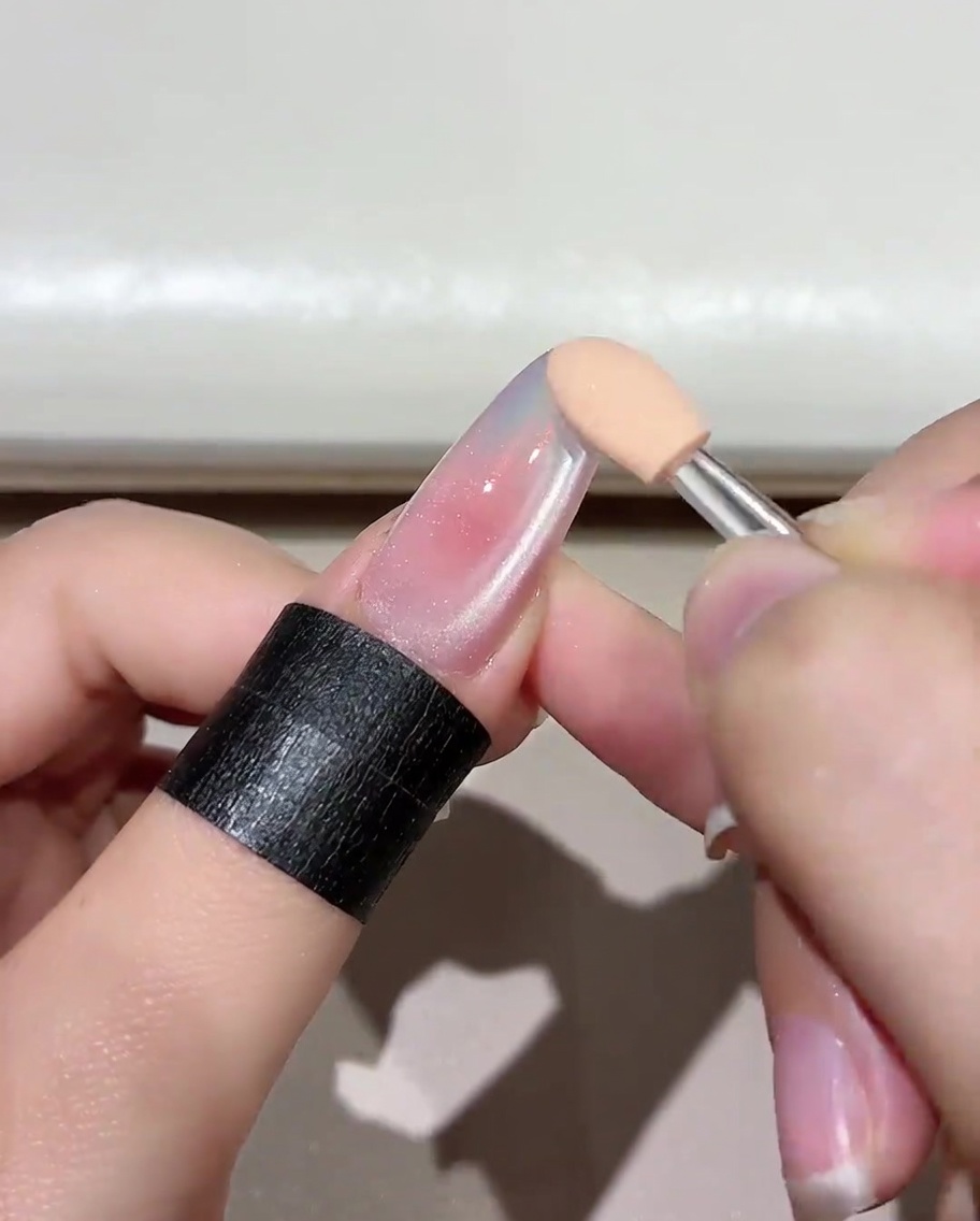 Una uña manicurada con una capa base de gel Jade D05 curándose dentro de una lámpara UV/LED.