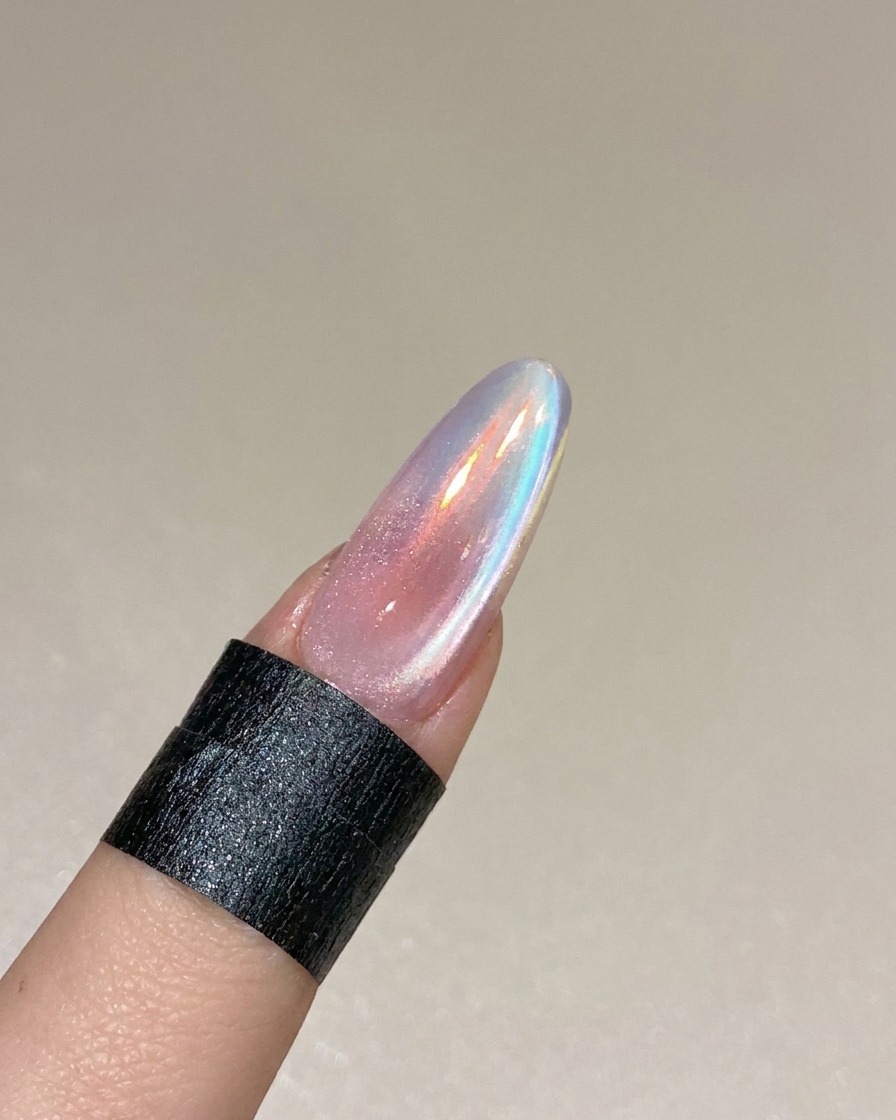 Un diseño de uña cat eye terminado curándose dentro de una lámpara profesional UV/LED.