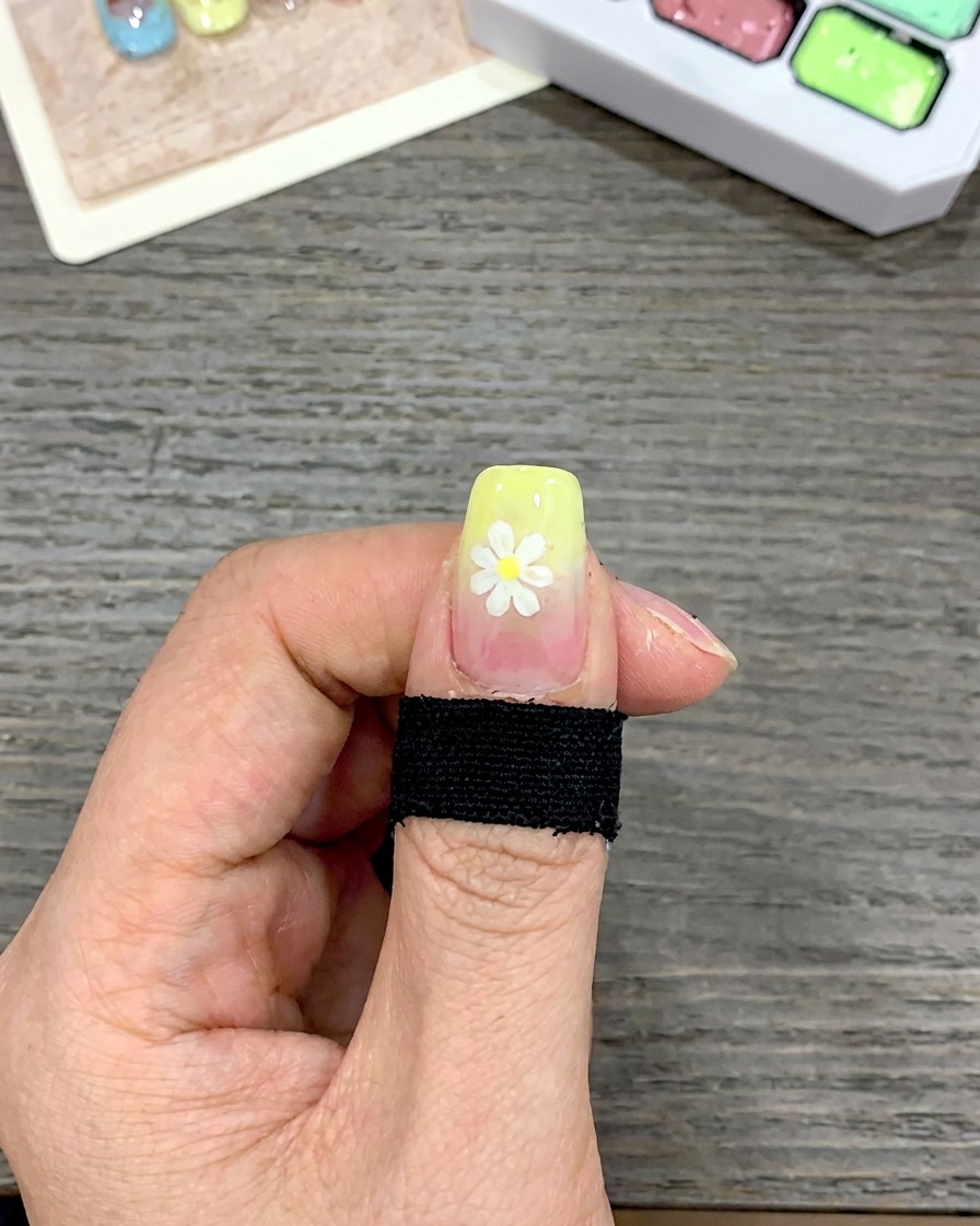 Primer plano de una uña con una capa gruesa de esmalte de gel amarillo aplicada en la punta con un pincel de punta cuadrada.