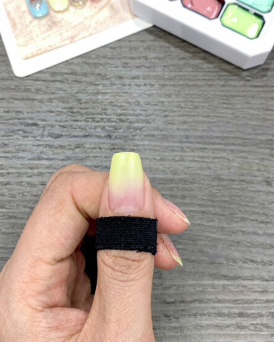 Primer plano que muestra un degradado suave de amarillo a transparente en una uña creado al dar toques con una esponja.