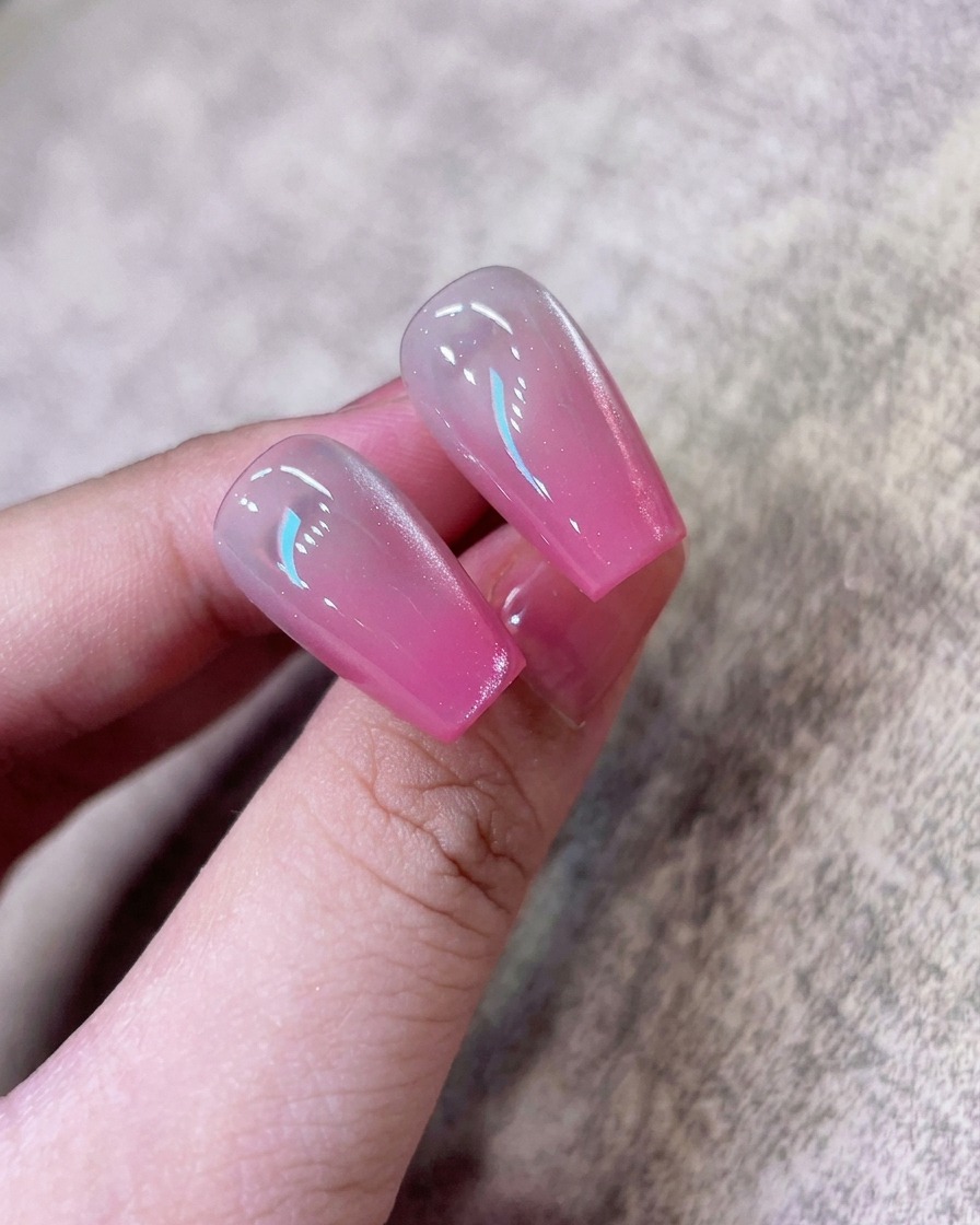 Una herramienta magnética cerca de la uña para agrupar las partículas brillantes en una línea concentrada de cat-eye.