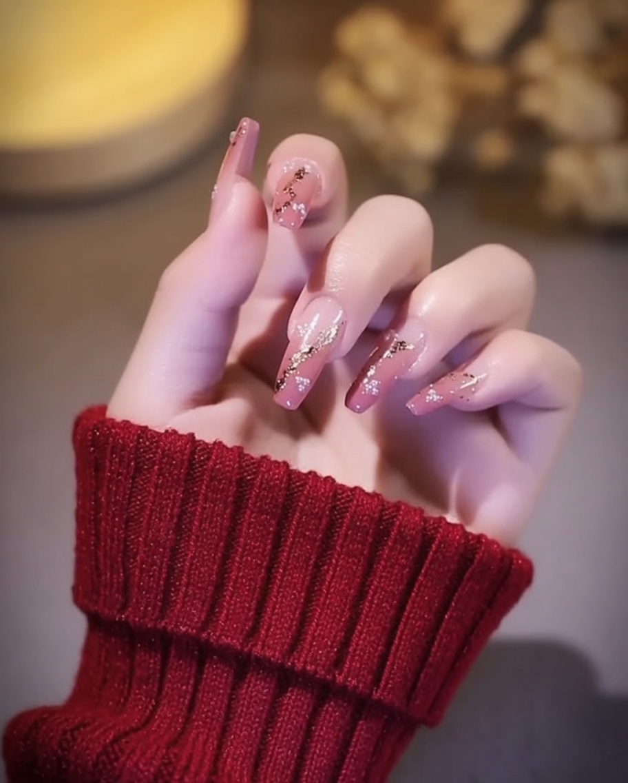 Uñas con detalles de pan de oro siendo curadas bajo una lámpara UV/LED.