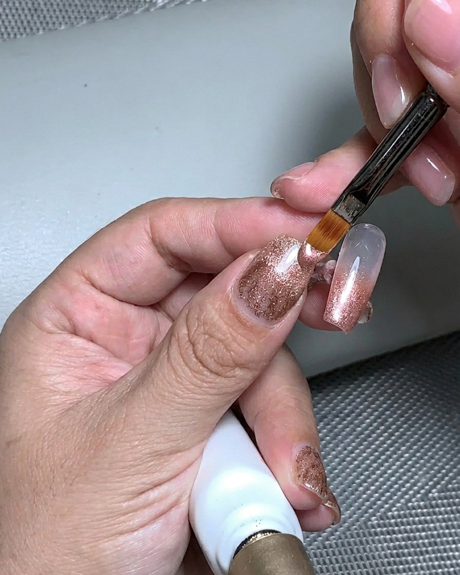 Una mano colocada bajo una lámpara UV para curar la capa de gel de construcción.