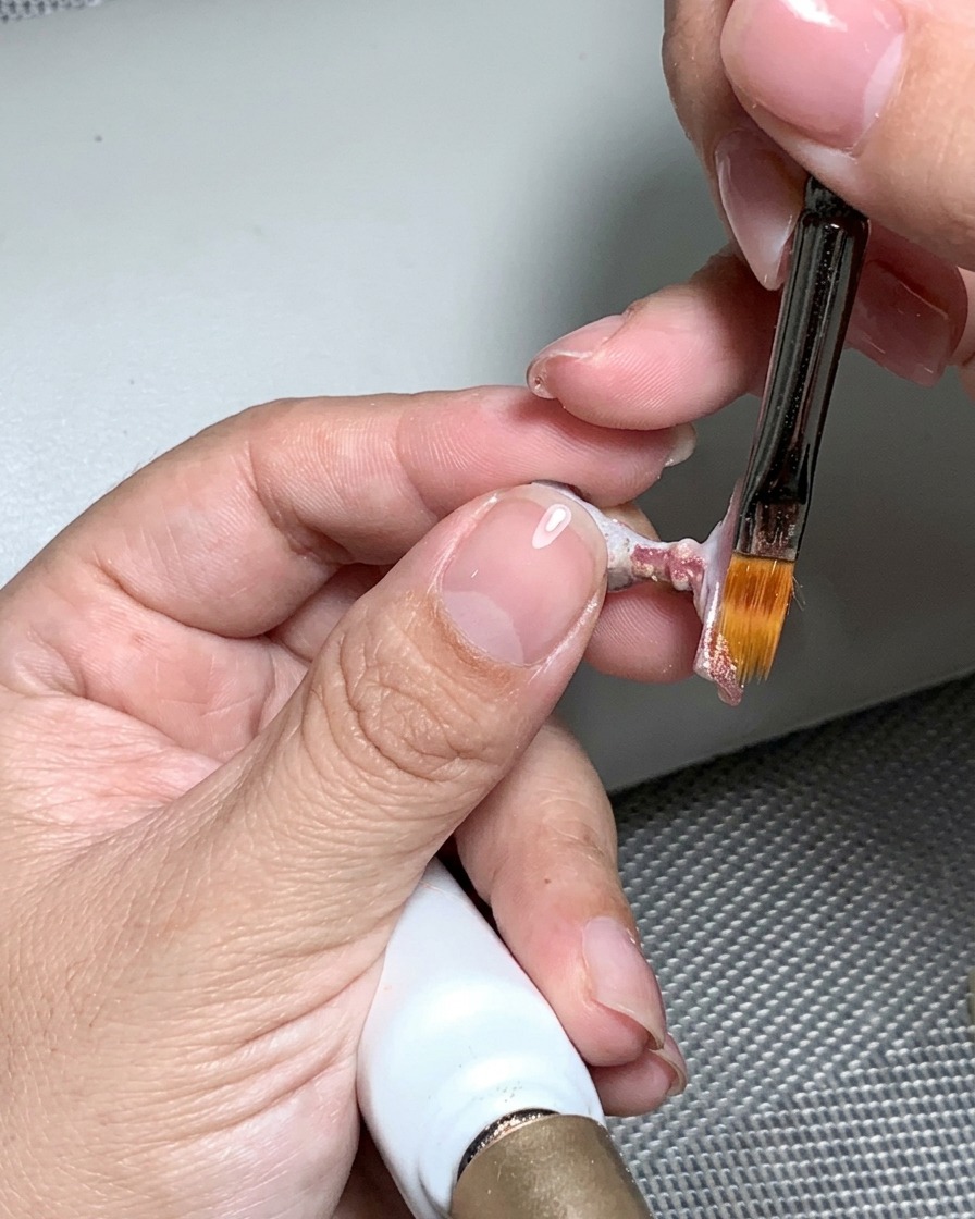 Una lima de uñas utilizada para pulir la superficie curada hasta dejarla suave y uniforme.