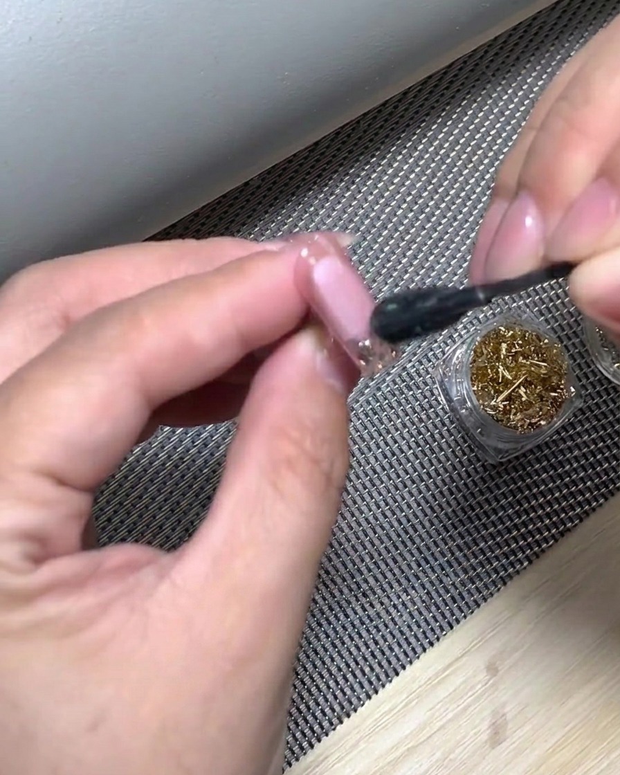 Una mano colocada dentro de una lámpara UV para curar la punta degradada blanca recién aplicada.