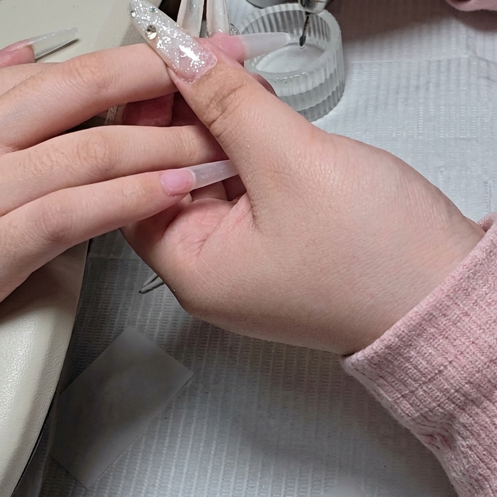 Primer plano que muestra una pequeña fresa de bola siendo utilizada para la limpieza precisa del área de la cutícula.