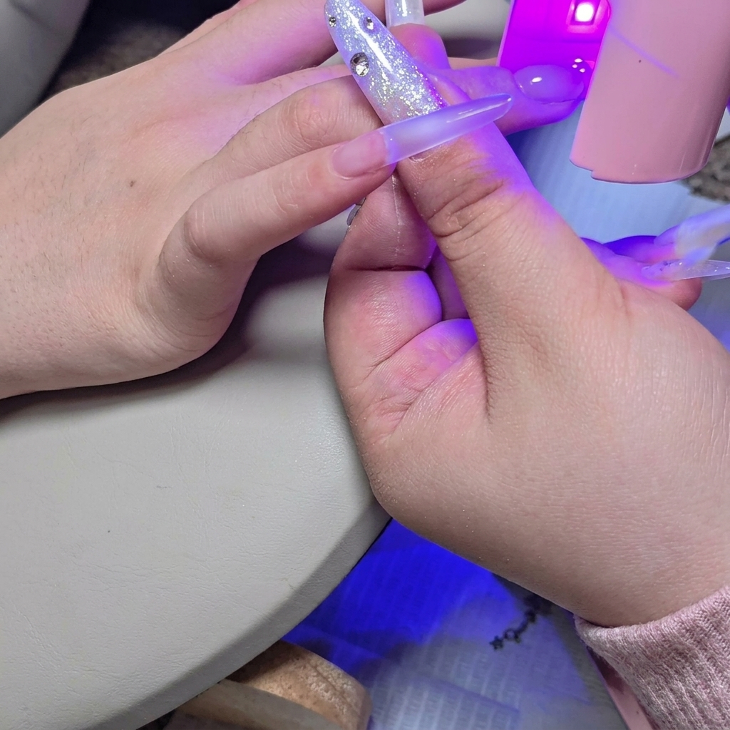 Mini lámpara UV/LED colocada sobre la uña para curar rápidamente la segunda capa de gel constructor.
