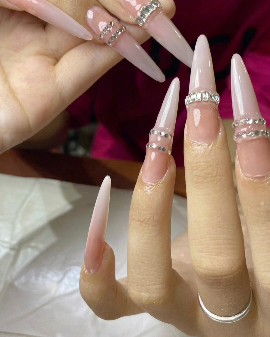 Un pincel mezclando esmalte de gel blanco lechoso sobre la base nude en la superficie de la uña.