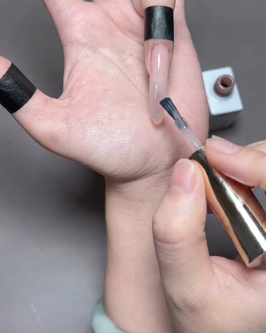 Un dedo con esmalte en gel recién aplicado colocado dentro de una lámpara de uñas para su curado.