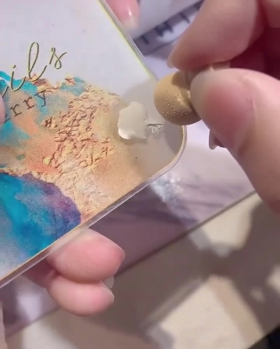 Primer plano que muestra una esponja de maquillaje blanca cargada con esmalte de gel blanco desde una paleta.