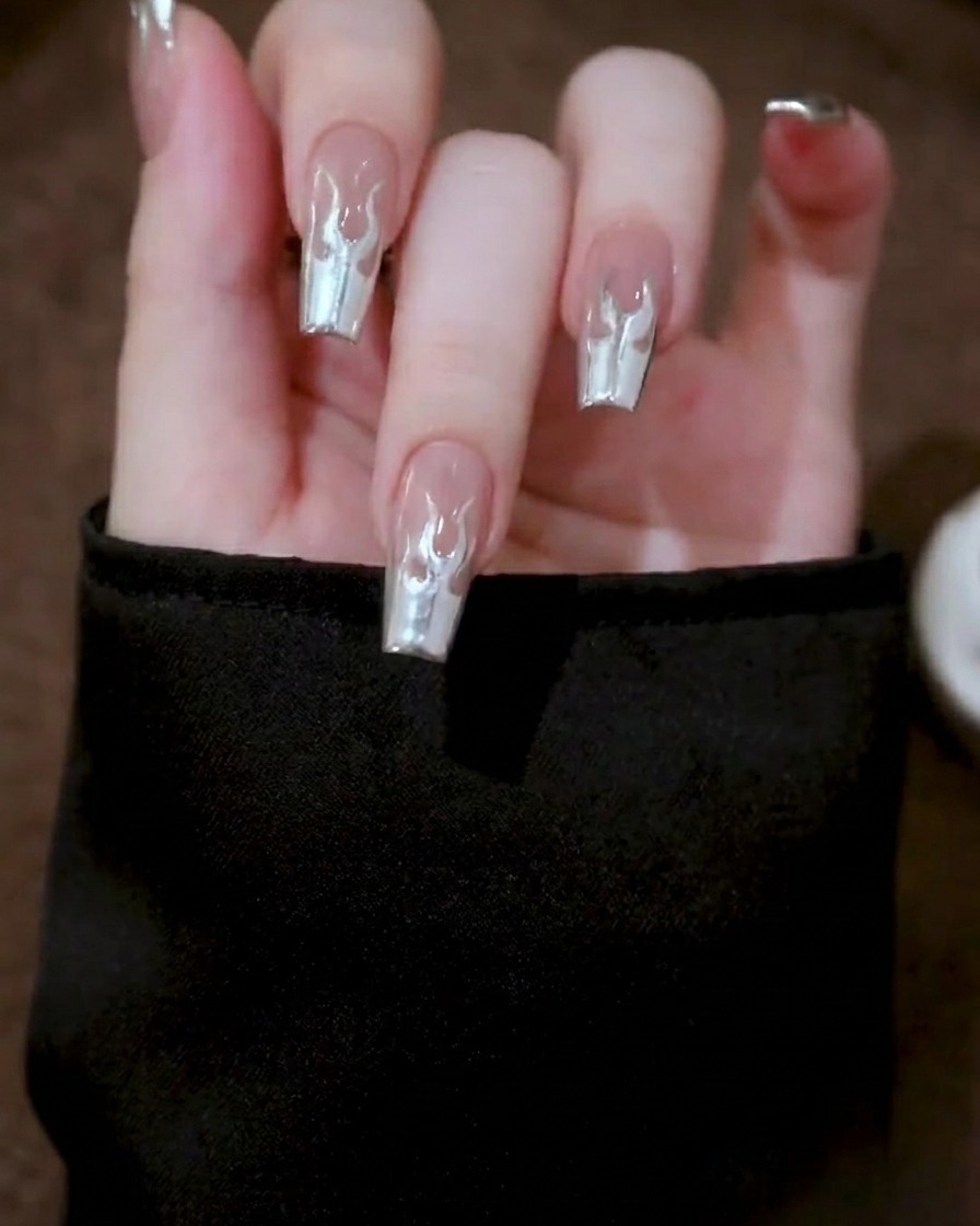 Primer plano de una mano colocada dentro de una lámpara de uñas profesional, con el diseño de gel metálico pasando por el proceso de curado.