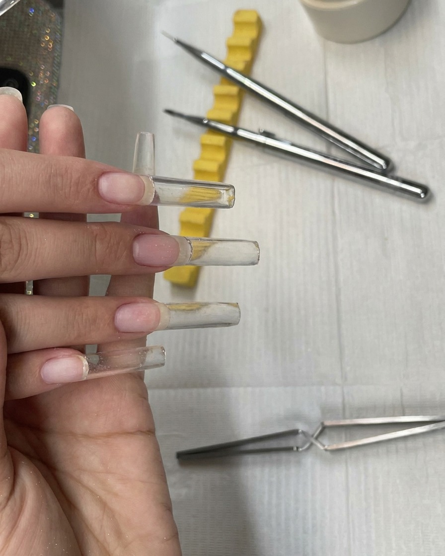 Cuatro extensiones de uña de gel extra largas, construidas y sin curar, antes del limado.