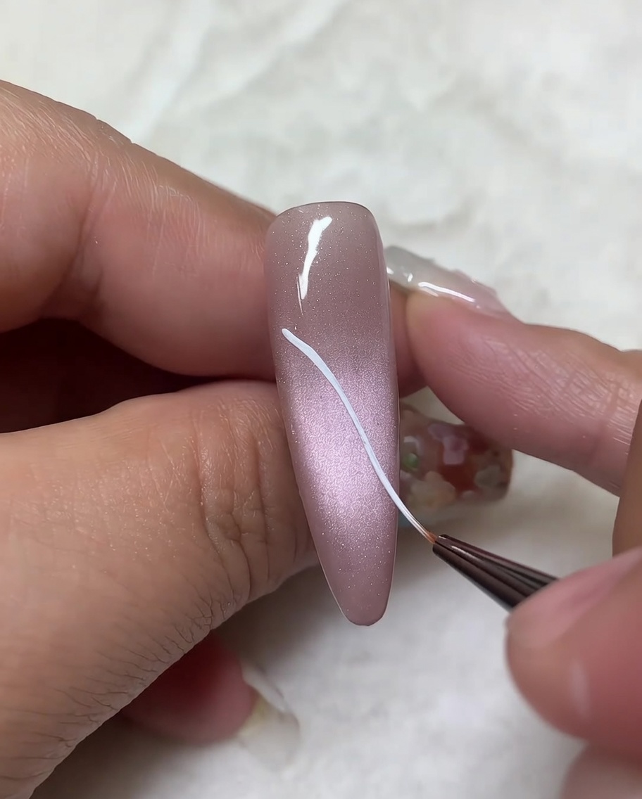 Un pincel liner fino agregando líneas curvas a los contornos diagonales dibujados previamente para completar la forma del ala superior.