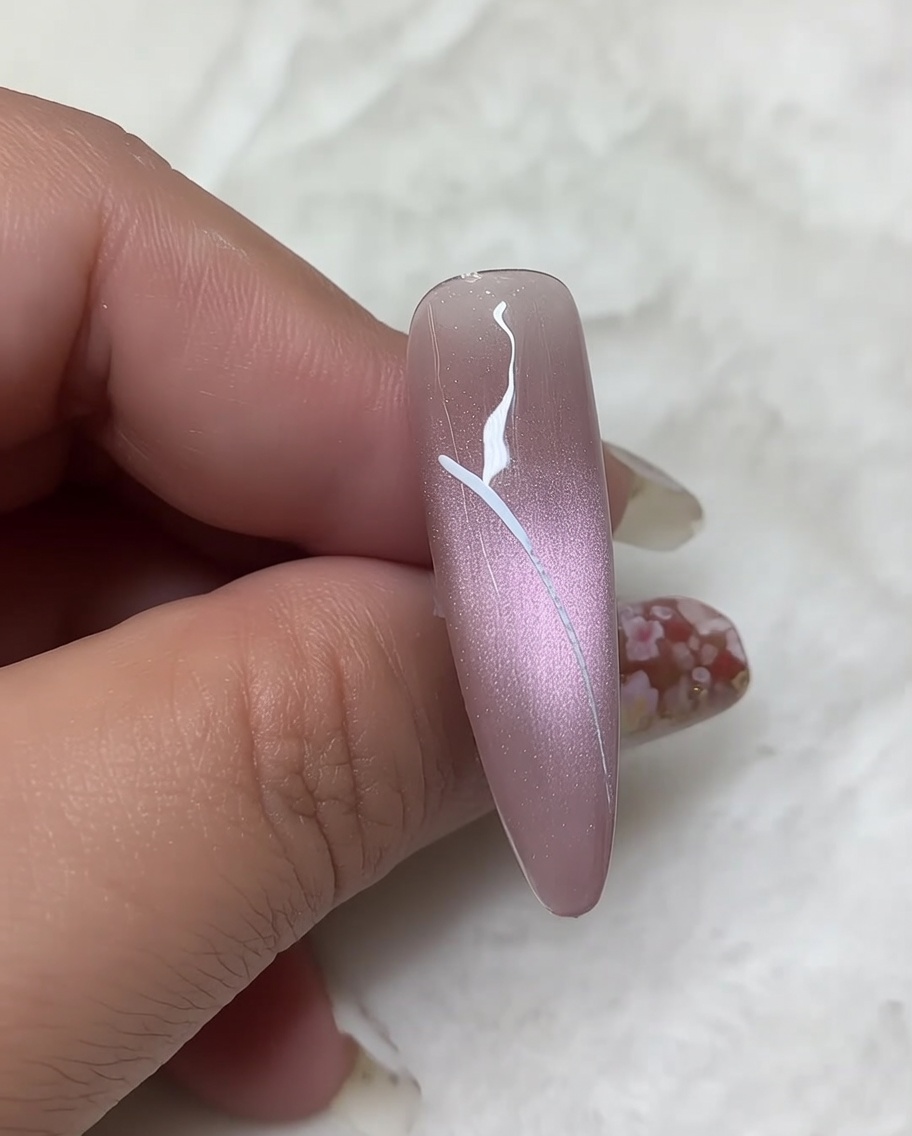 Un pincel liner fino dibujando los contornos de las alas inferiores, curvándolos para conectarlos de nuevo a la línea vertical central del cuerpo.