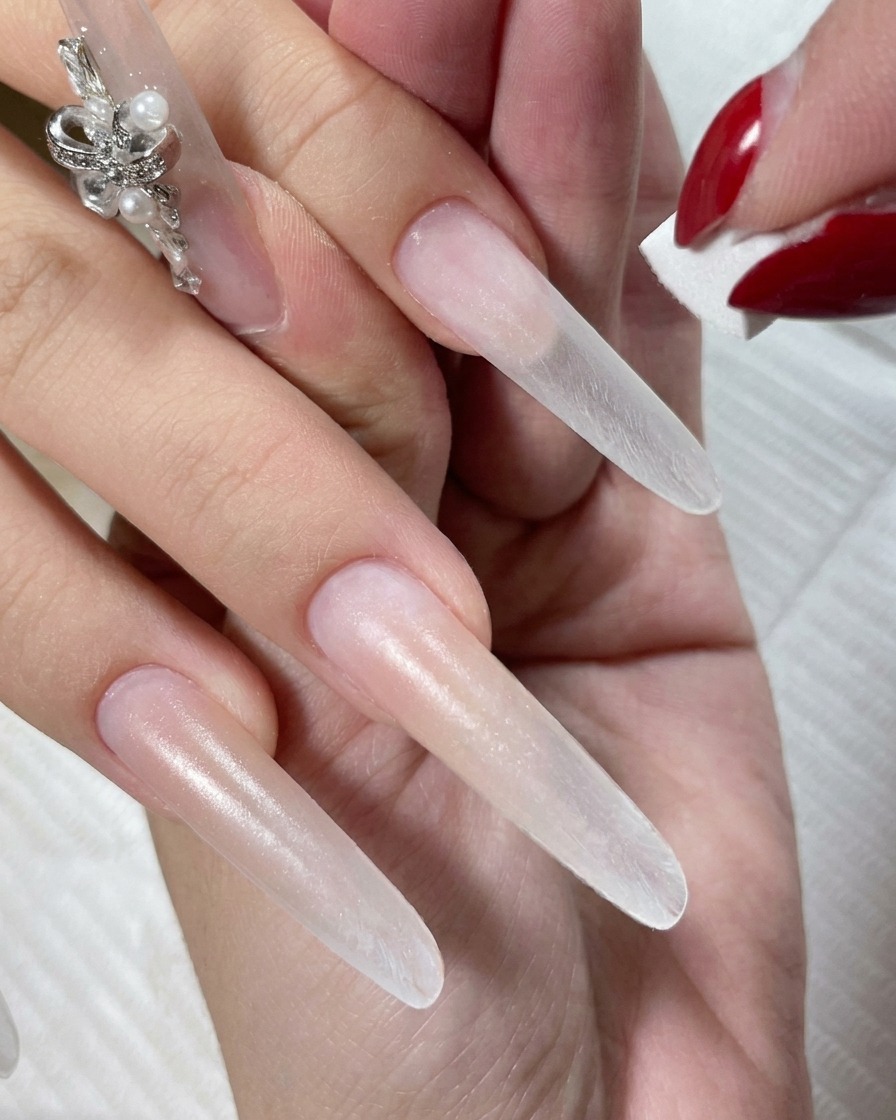 Una mano reposando dentro de una lámpara LED mientras se seca el esmalte en gel nude.