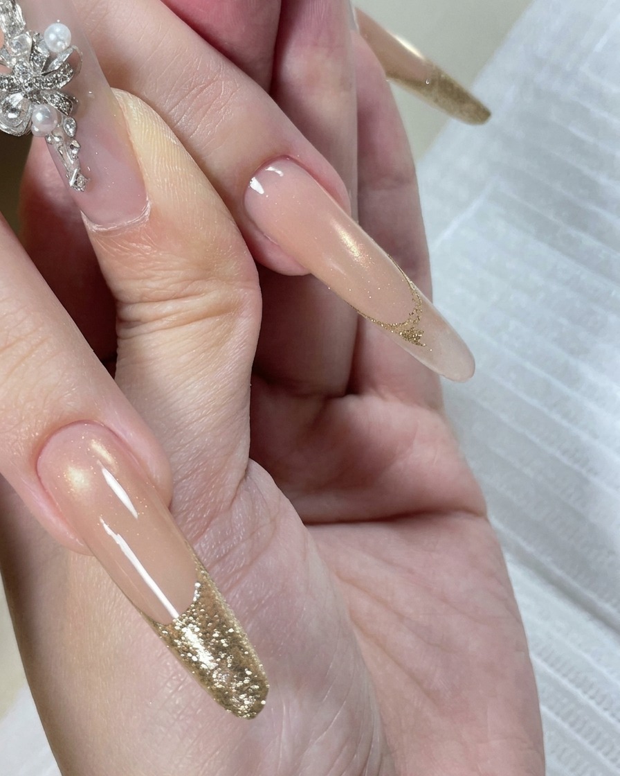 Una mano dentro de una lámpara de uñas LED con las puntas iluminadas por la luz durante el proceso de curado.