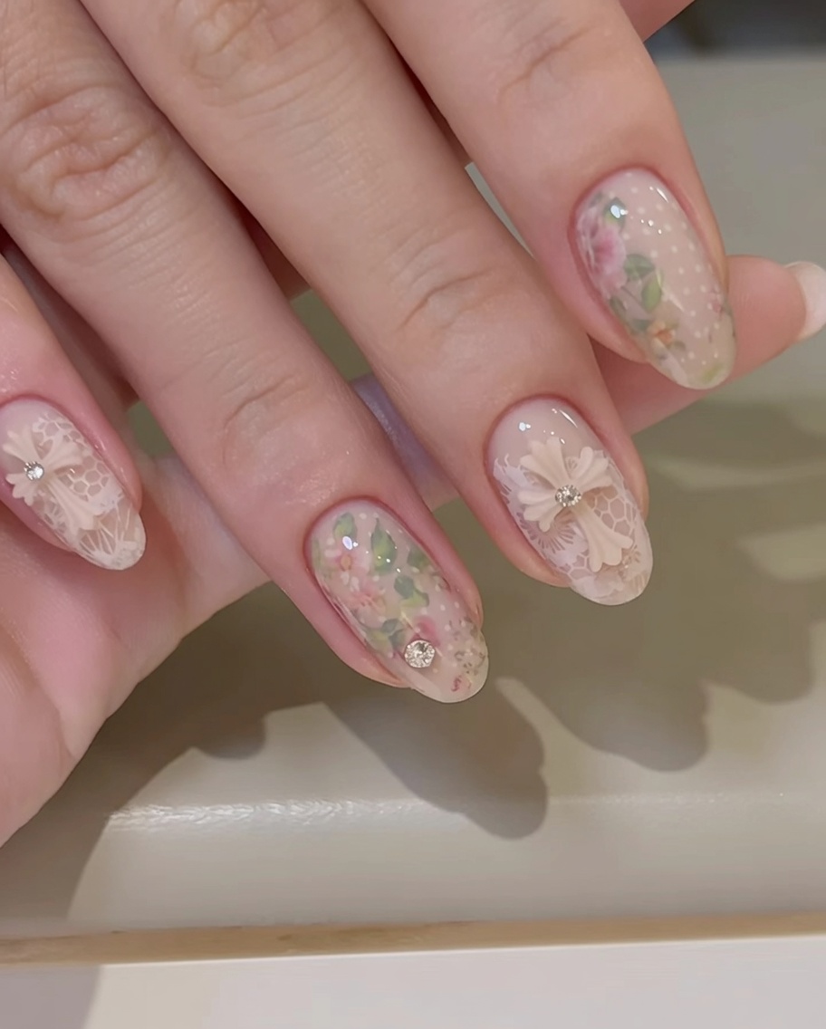 Un pincel aplicando una capa de gel transparente brillante sobre una uña decorada con foil de rosas.