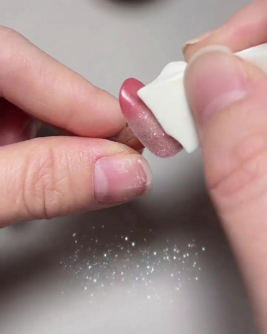Primer plano de uñas ojo de gato finalizadas sometiéndose a su curado final dentro de una lámpara UV/LED.