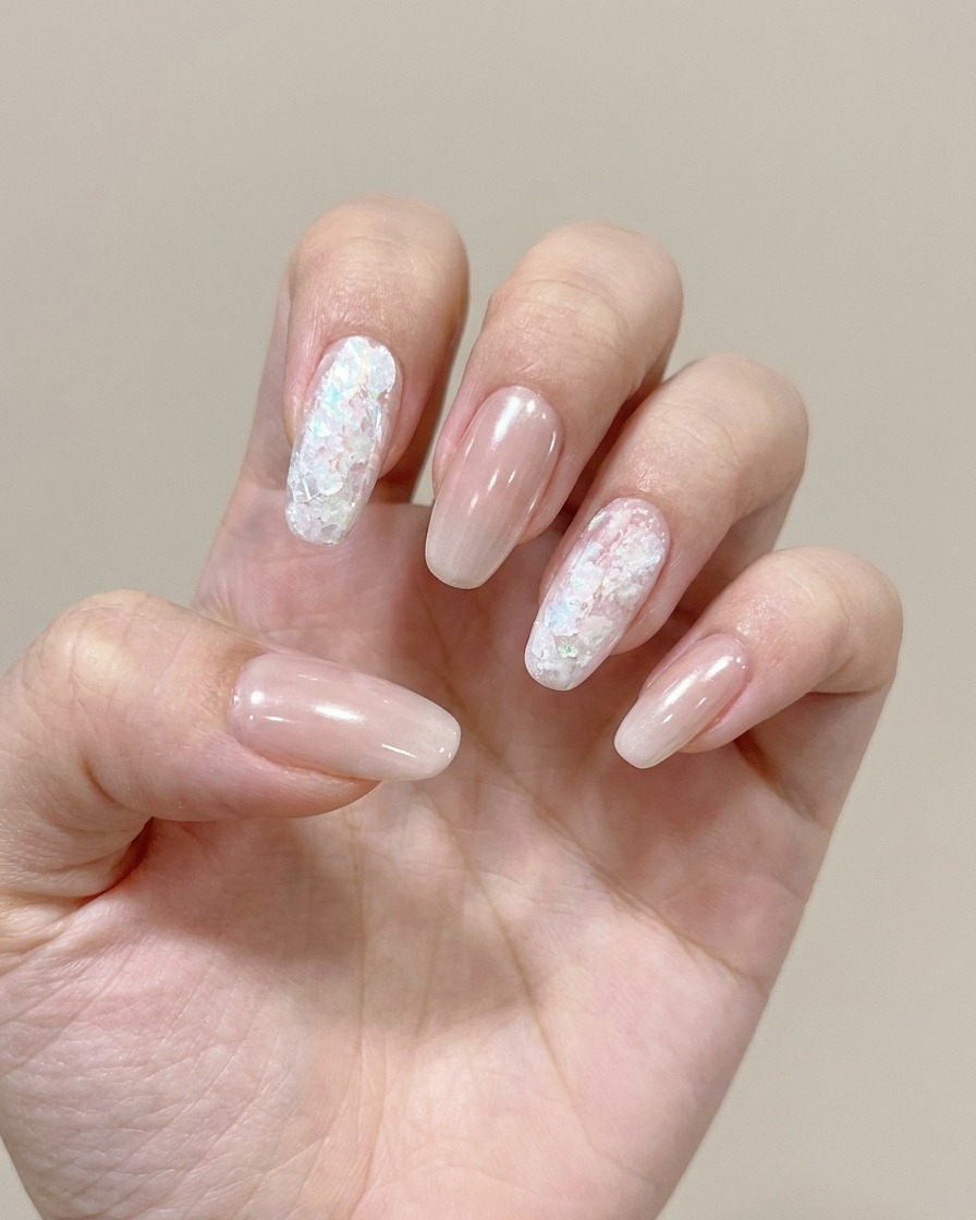 Primer plano que muestra una esponja aplicando un gel de color suave en la punta de una uña para crear un efecto ombré.