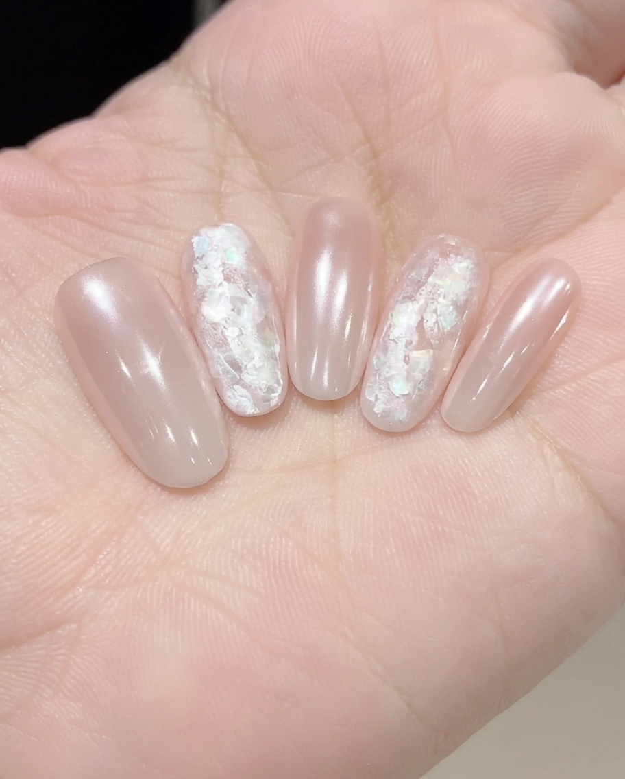 Aplicando un gel reforzador transparente sobre el nail art incrustado para alisar y sellar la superficie.