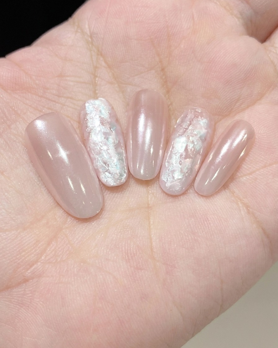 Un pincel de uñas aplicando una capa fina y brillante de Fine Pearl Glue sobre una uña.