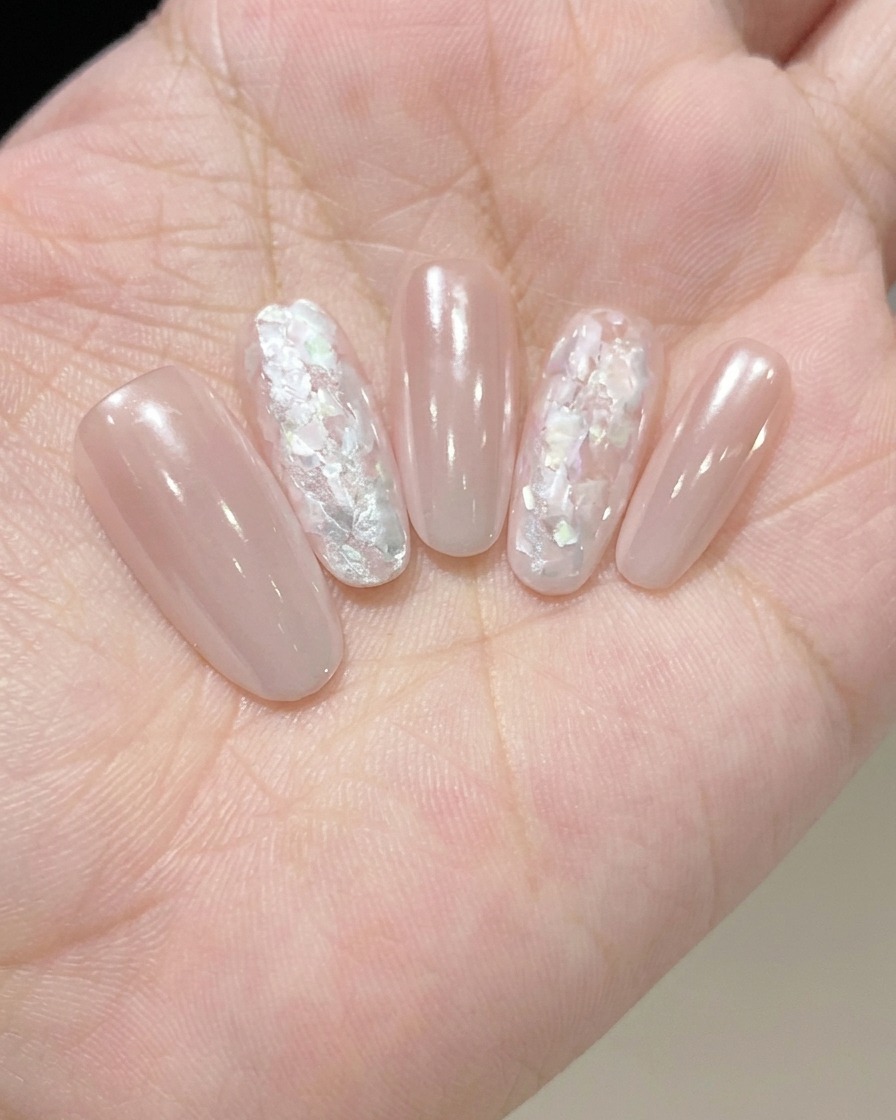 Un pincel aplicando un top coat transparente y brillante para sellar y proteger el diseño de uñas completado.