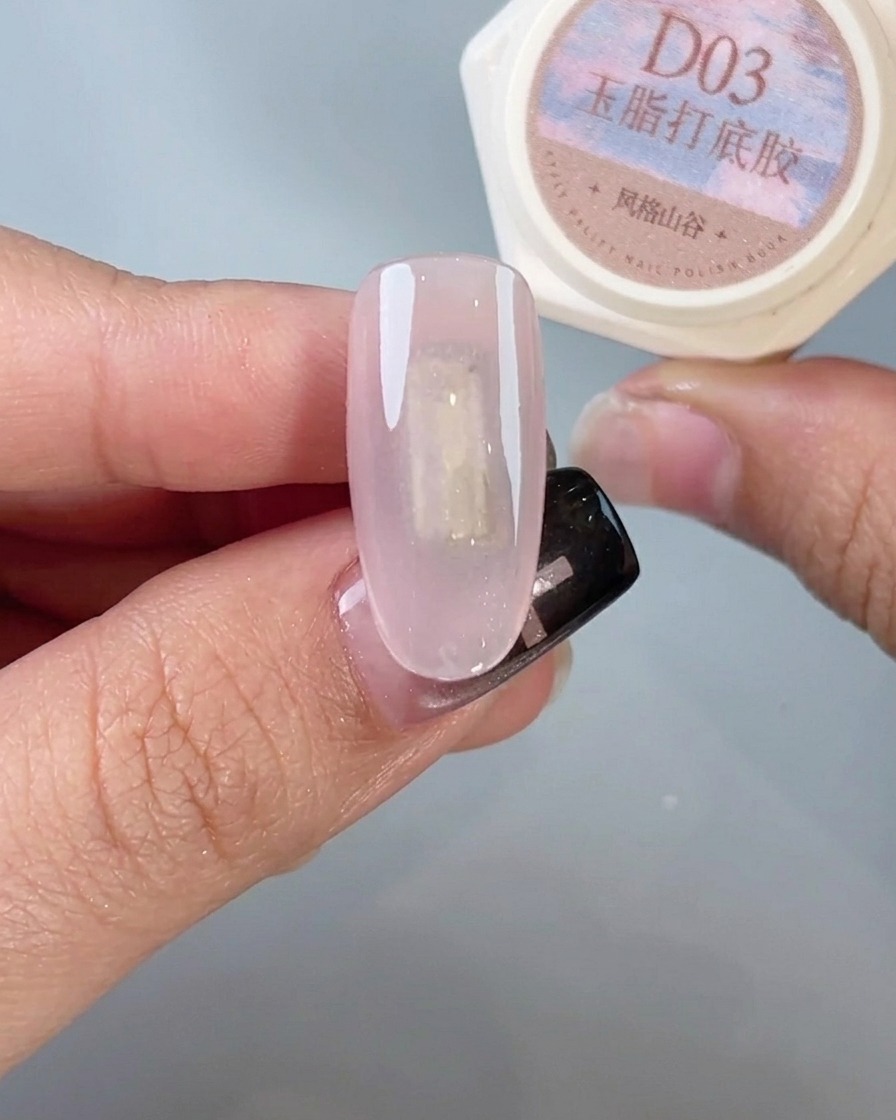 Un pincel de uñas aplicando un top coat final y brillante a una uña cromada terminada.