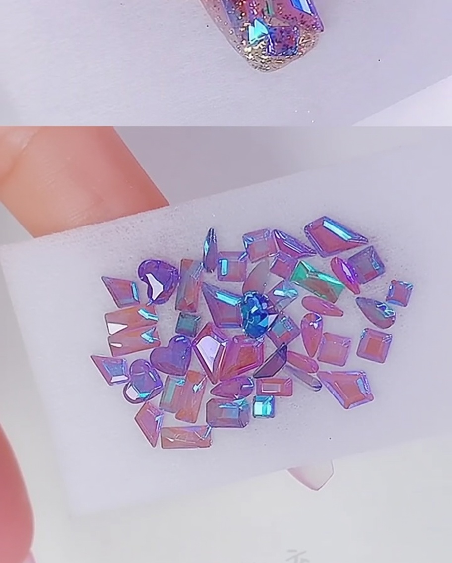 Pequeños puntos de pegamento transparente aplicados en la uña para fijar las decoraciones de cristal.