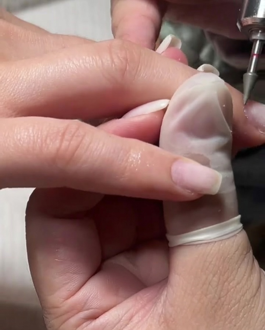 Una fresa de grano fino usándose sobre una cutícula humedecida para una exfoliación suave.