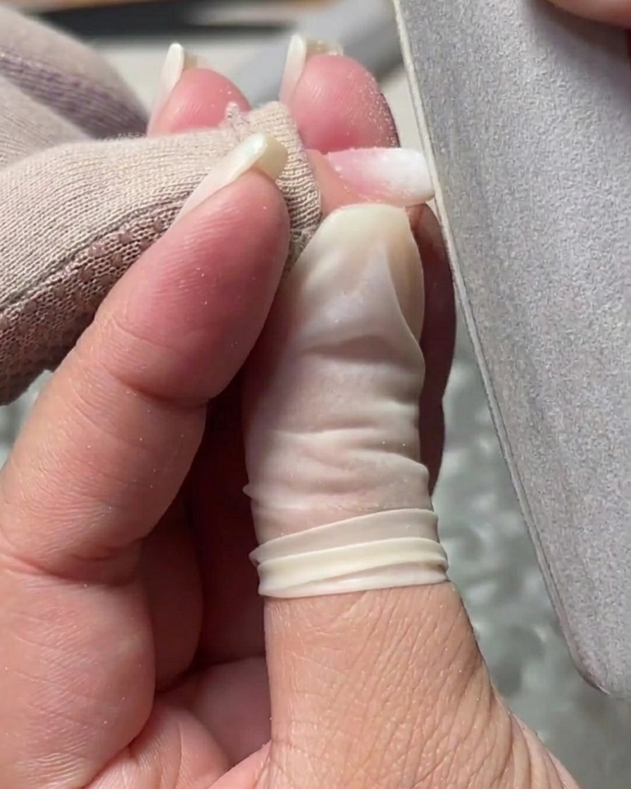 Una lima manual suavizando la superficie y refinando los bordes de la uña de gel.