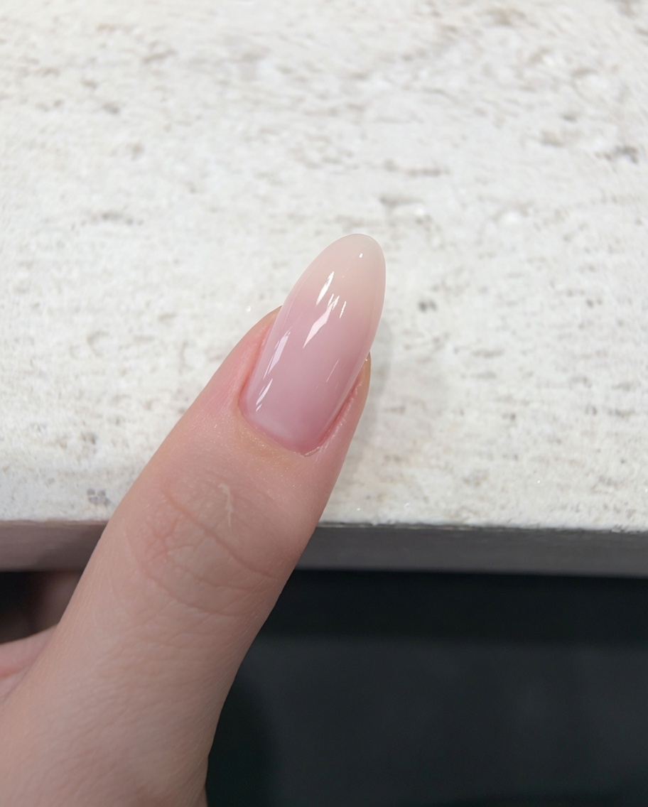 Un dedo descansando dentro de una lámpara de uñas UV/LED durante el proceso de curado.