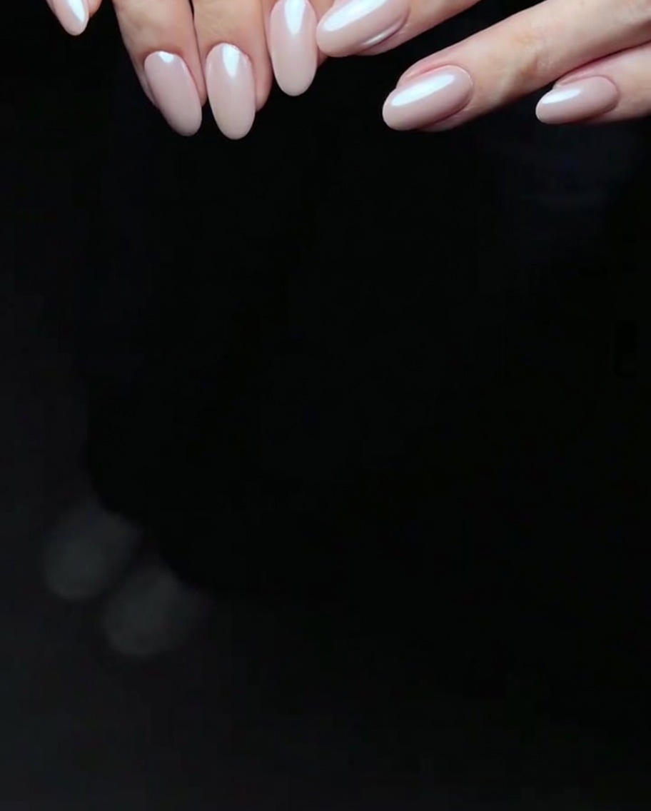 Una mano reposando dentro de una lámpara LED para uñas, con los dedos visibles bajo la luz de curado.