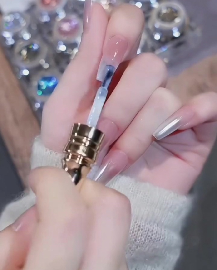 Un pincel aplicando esmalte de gel blanco en el borde libre de la uña.