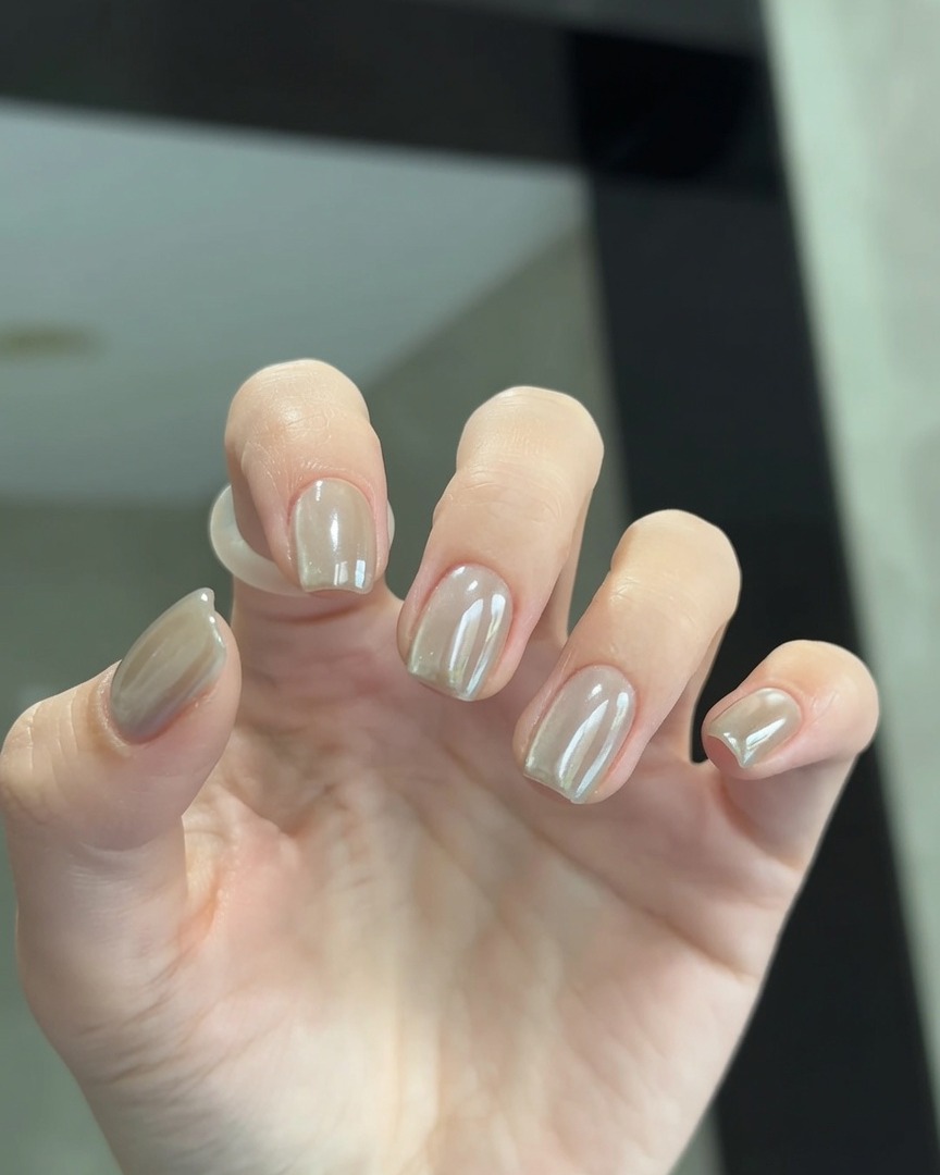Primer plano de una mano con las uñas dentro de una lámpara LED de curado.