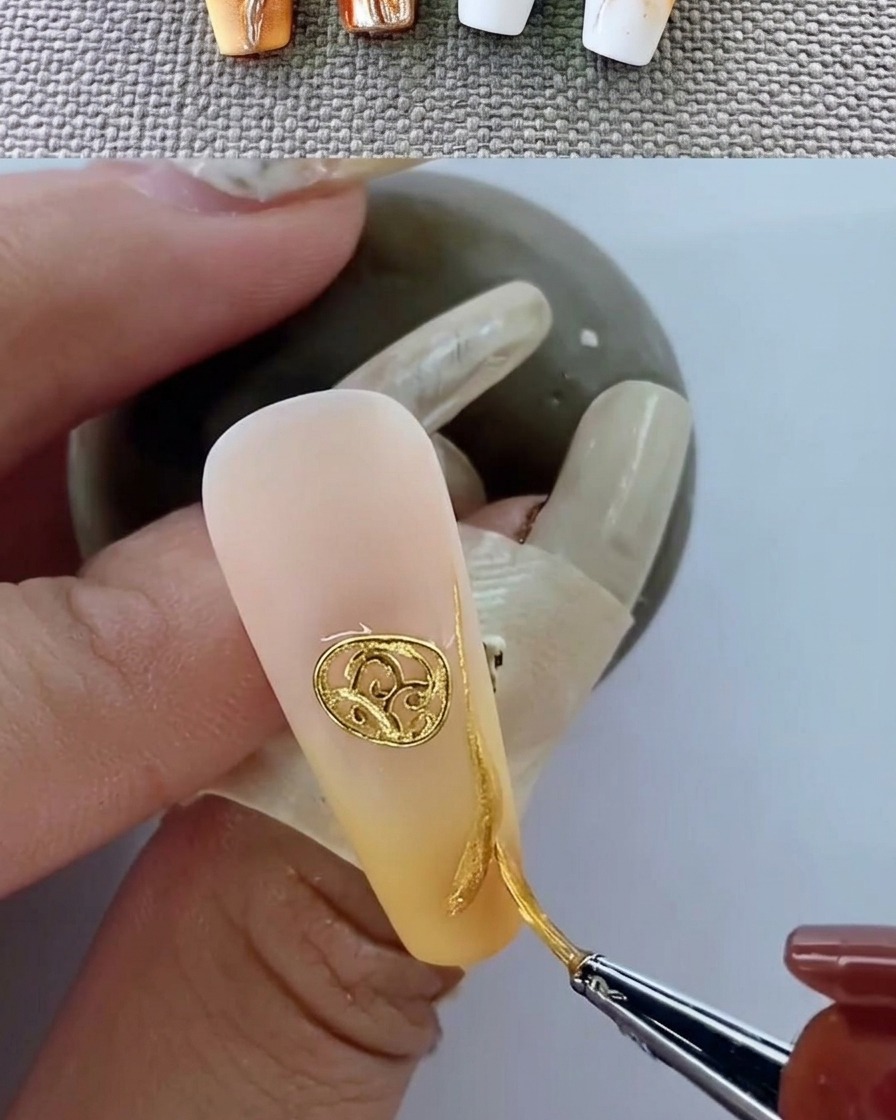 Primer plano de una uña manicurada con un emblema metálico curándose bajo una lámpara UV.