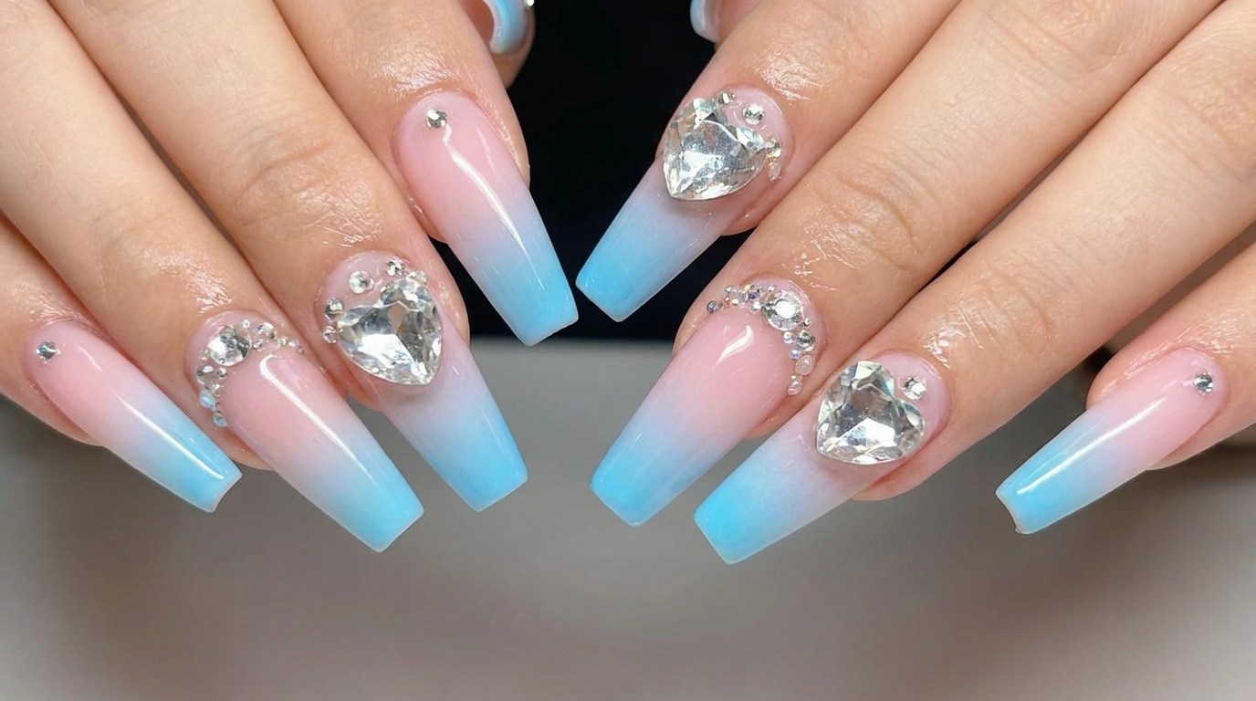 Uñas degradadas en rosa y azul con detalles de pedrería