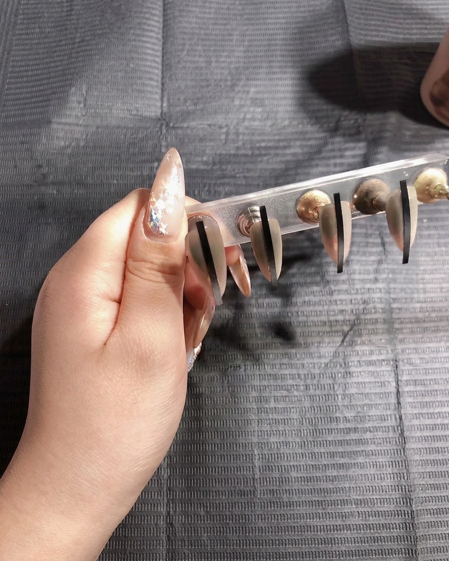 Las uñas curándose bajo la lámpara UV por segunda vez.