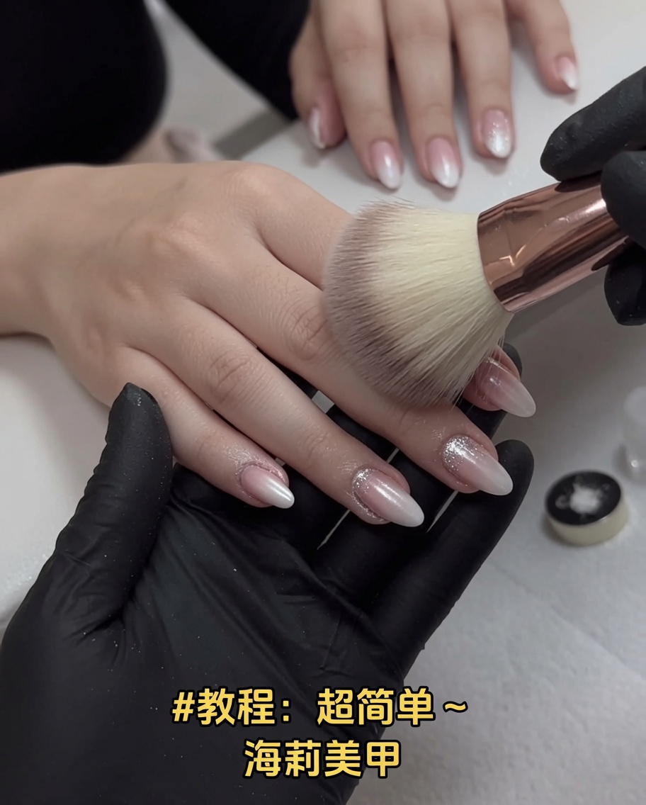Una brocha de maquillaje suave y grande barriendo el exceso de polvo de cromo sobre las uñas.