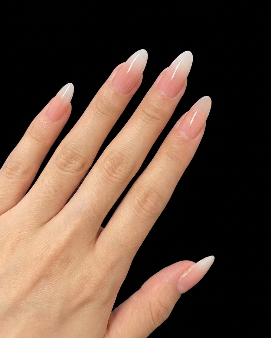 Un pincel de uñas aplicando una pequeña cantidad de gel con glitter fino al centro de una uña.