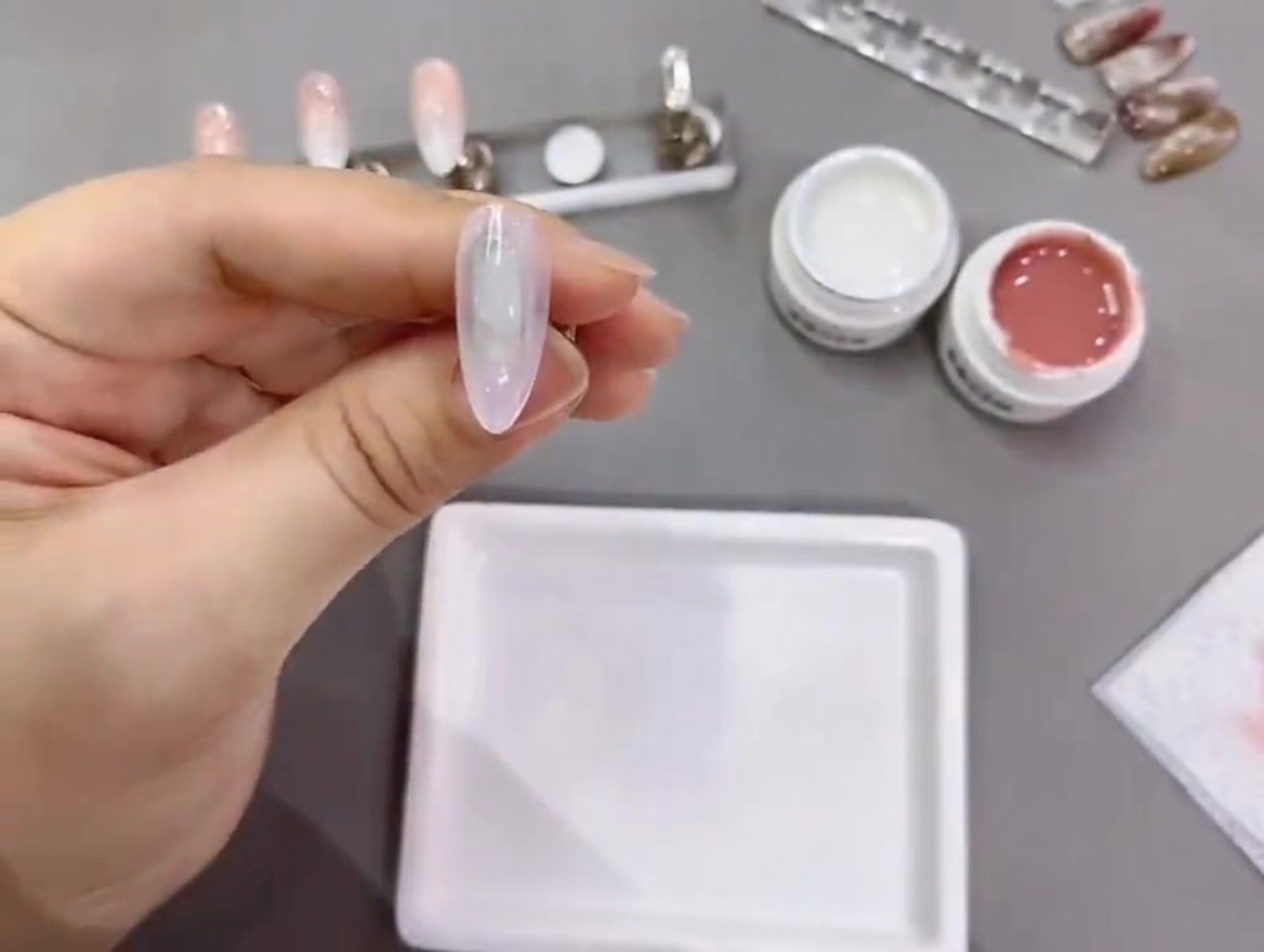 Un tip de uña curándose bajo una lámpara profesional UV/LED.