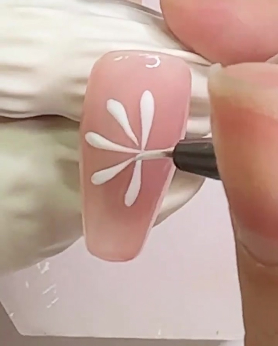 Una uña con un patrón denso de líneas radiales blancas para la margarita.